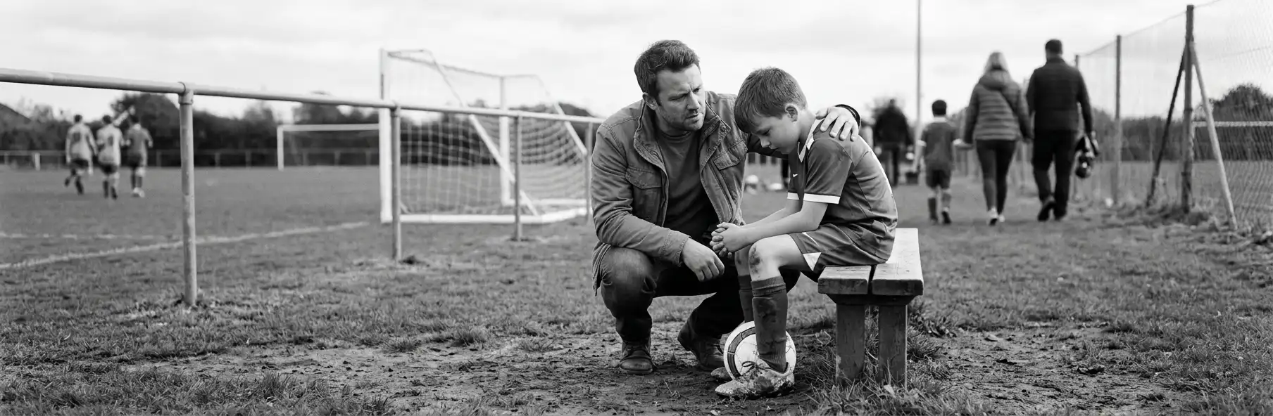 Young football player sitting alone in the changing room with his bag beside him
