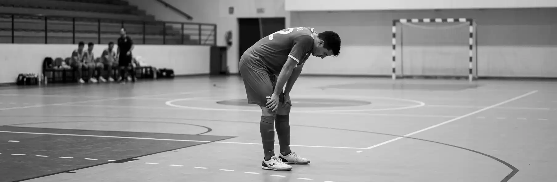 Four futsal players talking in a huddle in the middle of the court during training