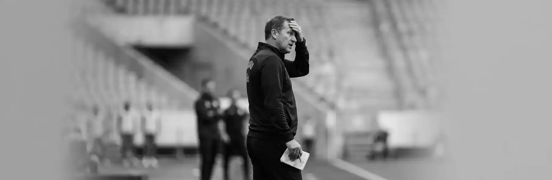 Football manager talking to the squad in the dressing room during the early season