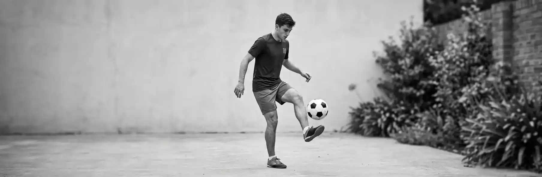 Football player practising ball control alone in a small space at home