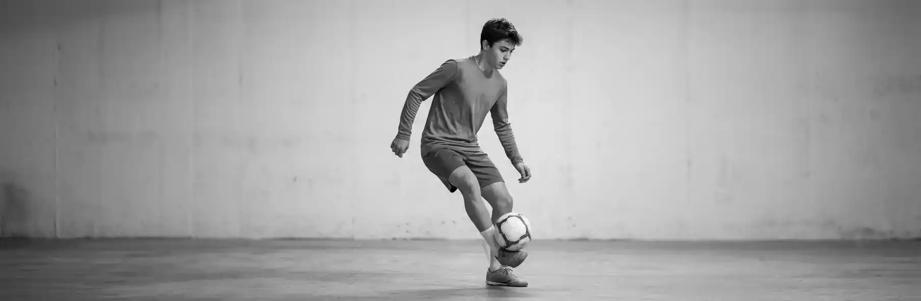 Futsal player practising ball control alone in a small space at home