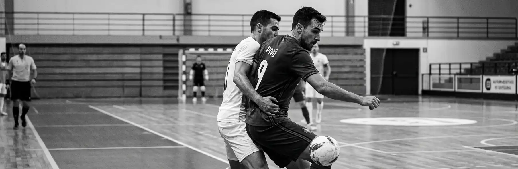 Futsal player in the pivot position being closely marked by a defender