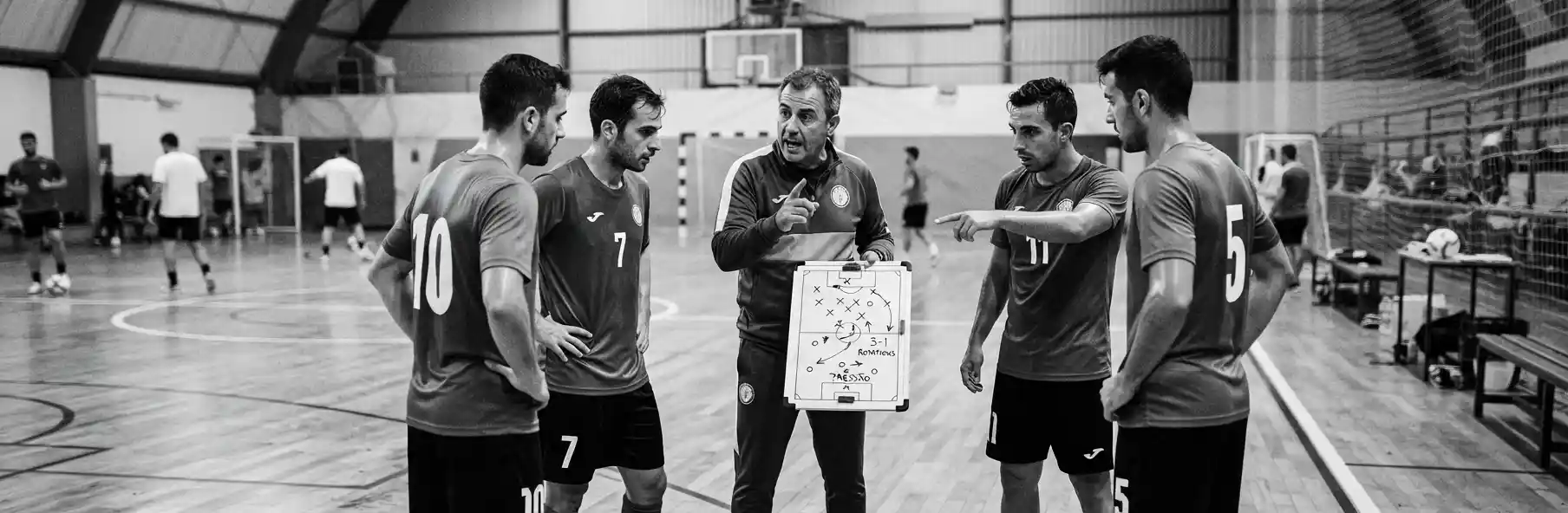 Coach explaining a tactical system on a futsal tactics board