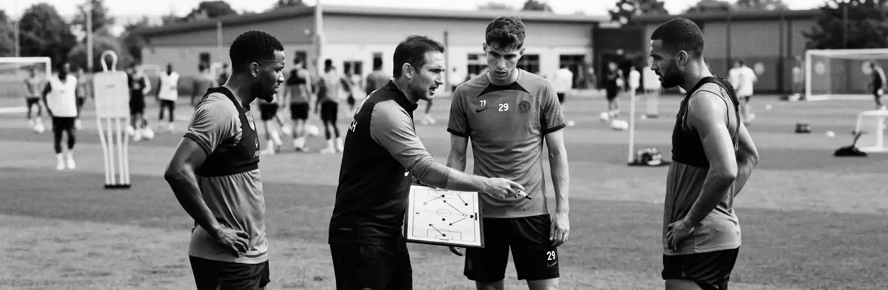Manager explaining a tactical drill to a new signing recently arrived at the squad