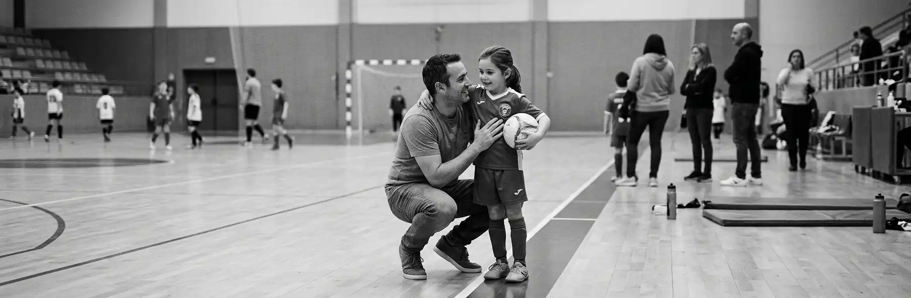 Parent talking to a young futsal player son after training