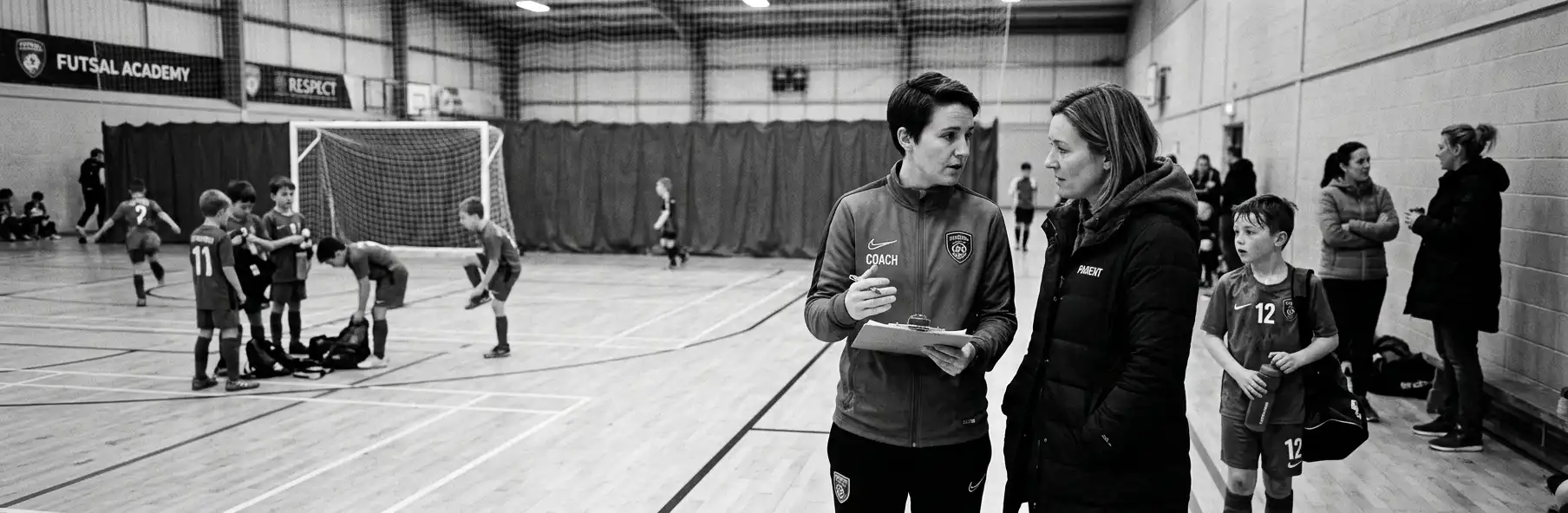 Futsal coach talking with parents of young players